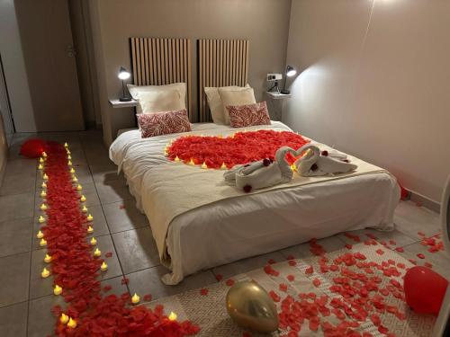 - une chambre avec un lit recouvert de roses rouges dans l'établissement Oasis Villa Magescq Votre paradis avec Piscine et Jacuzzi, à Magescq