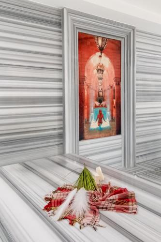 a table with a bouquet of flowers in front of a window at Riviera Zen Hotel Adult Only in Alanya