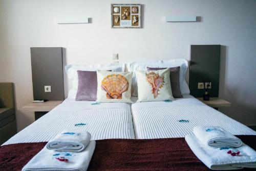a bed with two towels and pillows on it at Drenia Studios in Ammouliani