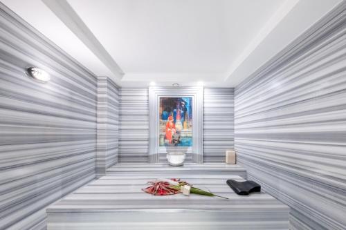 a room with a bench with flowers and a painting at Riviera Zen Hotel Adult Only in Alanya