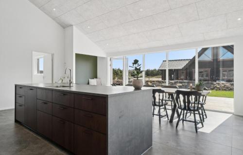 a kitchen with a counter and a table with chairs at 5 Bedroom Gorgeous Home In Skjern in Skjern