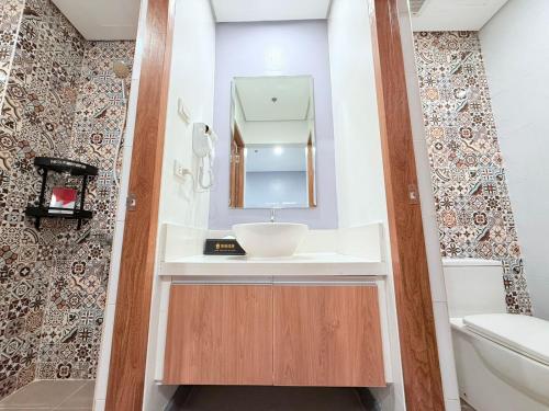 un baño con lavabo y espejo en Sapphire Seaview Park Suites near Okada, Solaire, MOA, NAIA Airport, Bayview, en Manila