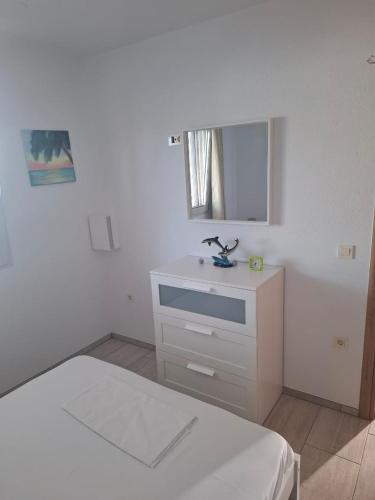 a white bedroom with a bed and a sink at Villa Dadis in Chania
