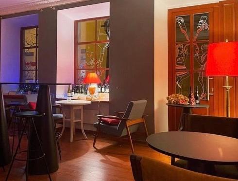 a restaurant with a bar with tables and chairs at Grotthuss Boutique Hotel Vilnius in Vilnius