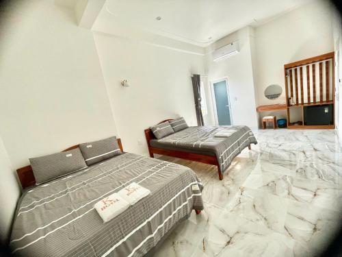 two beds in a room with marble floors at K Hotel Phú Quý in Cu Lao Thu