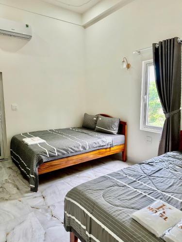 a bedroom with two beds and a window at K Hotel Phú Quý in Cu Lao Thu