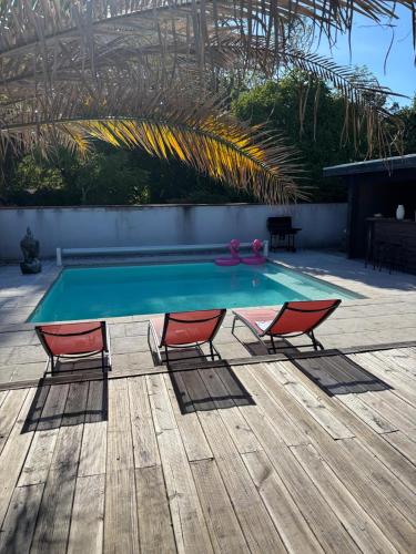 - une table de ping-pong et 2 chaises sur la terrasse dans l'établissement Oasis Villa Magescq Votre paradis avec Piscine et Jacuzzi, à Magescq