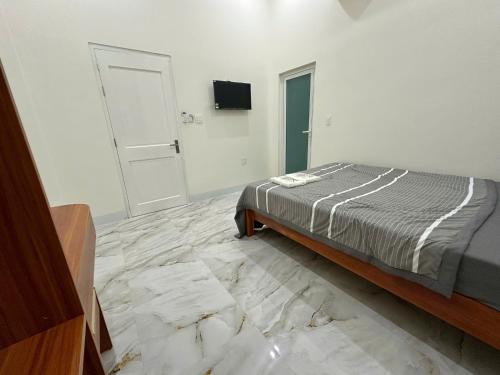 a bedroom with a bed and a tiled floor at K Hotel Phú Quý in Cu Lao Thu