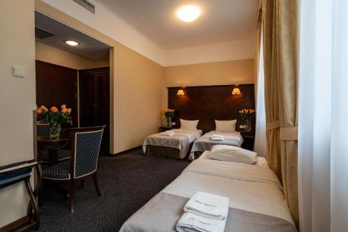 a hotel room with two beds and a television at Grand Sal in Wieliczka
