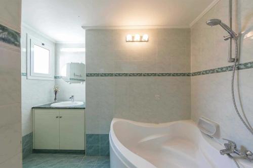 a bathroom with a bath tub and a sink at Pine Retreat in Argaka