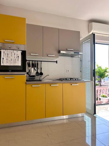 a kitchen with yellow cabinets and a stove at Apartment Laura in Senj