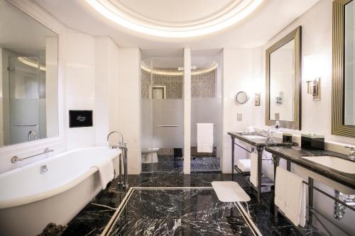 a bathroom with two sinks and a bath tub at Fairmont Peace Hotel on the Bund in Shanghai