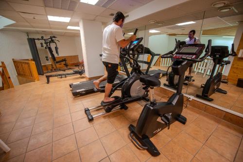 a man exercising on exercise bikes in a gym at Clouds Studio Alpin Luxury Cozy and Pool in Villars-sur-Ollon