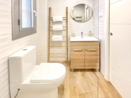 a bathroom with a toilet and a sink and a mirror at KS Plaza Catedral by Kaleria Suites in Almería