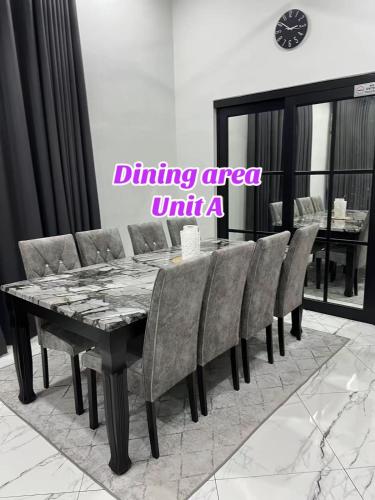 a dining area with a black table and chairs at ARZHomeStay unit A in Kuala Terengganu