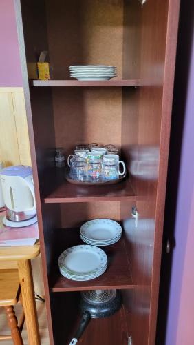 a wooden shelf with plates and dishes on it at Noclegi u Danuty in Groń