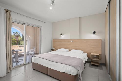 a bedroom with a large bed and a balcony at Pandream Hotel Apartments in Paphos City