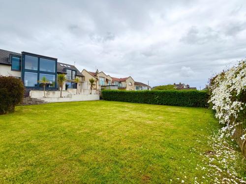 a house with a yard with a large lawn at Luxury Coastal Getaway in Portstewart