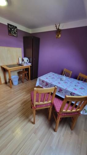 a room with a table and chairs and a purple wall at Noclegi u Danuty in Groń