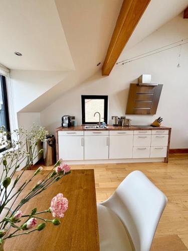 a kitchen with white cabinets and a wooden table at Luxury Coastal Getaway in Portstewart