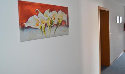a painting of yellow flowers hanging on a wall at Hotel Huber in Moosburg