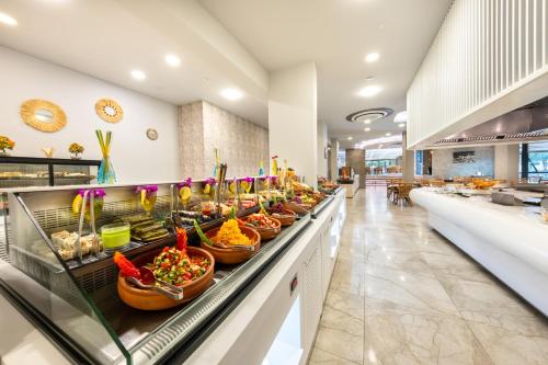 a buffet line with bowls of food in a restaurant at Riviera Zen Hotel Adult Only in Alanya