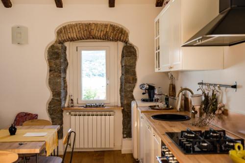 a kitchen with a stone archway and a sink and a table at Hurban Apartments La Casa dei Fiori in Trieste