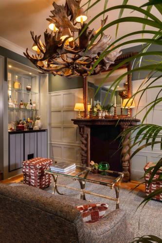 d'un salon avec une cheminée et un lustre. dans l'établissement Hôtel Aubépine, à Paris