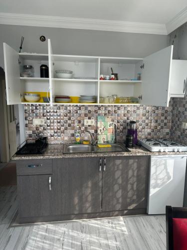 a kitchen with white cabinets and a sink at Delpina APART&OTEL in Pazar