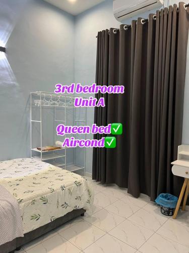 a bedroom with a bed and curtains in a room at ARZHomeStay unit A in Kuala Terengganu