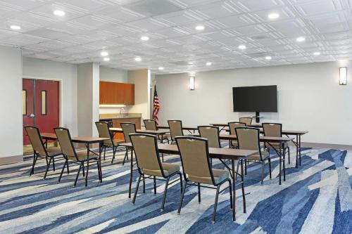 a conference room with tables and chairs and a tv at Comfort Inn & Suites Orlando North in Sanford