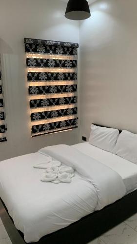 a bedroom with a white bed with a wine rack at Lamorange Luxurious Apartment in Mushin Halt