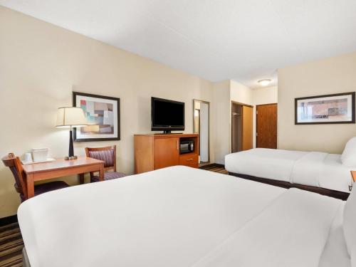 a hotel room with two beds and a television at Comfort Inn Metro Airport in Romulus