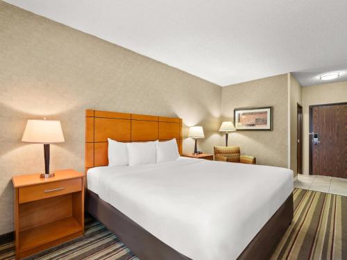 a large white bed in a hotel room at Comfort Inn Metro Airport in Romulus