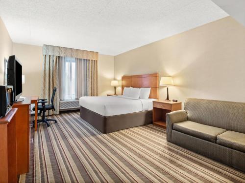 a hotel room with a bed and a couch at Comfort Inn Metro Airport in Romulus