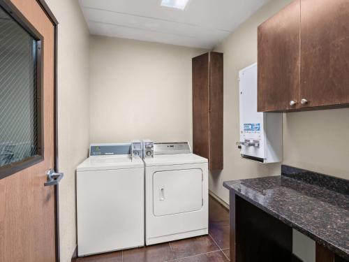 a small kitchen with a white washer and dryer at Comfort Inn Metro Airport in Romulus