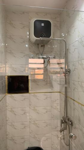 a bathroom with a shower with a tv on the wall at Lamorange Luxurious Apartment in Mushin Halt