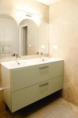 a bathroom with a white sink and a mirror at Maison Castor, balnéo et billard chez Ivona Vacances in Mimizan