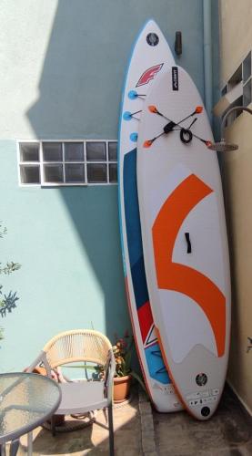 a surfboard leaned up against a wall with a clock on it at Drenia Studios in Ammouliani