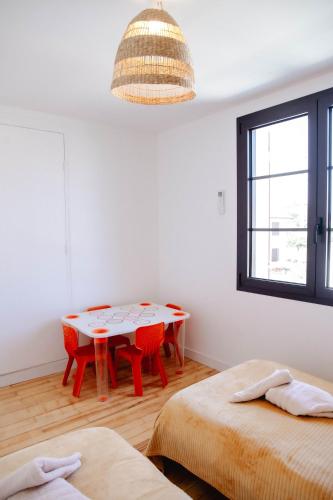 a white room with a table and red chairs at Maison Castor, balnéo et billard chez Ivona Vacances in Mimizan
