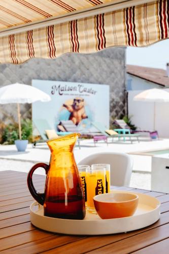 a table with a jug and two glasses of beer at Maison Castor, balnéo et billard chez Ivona Vacances in Mimizan