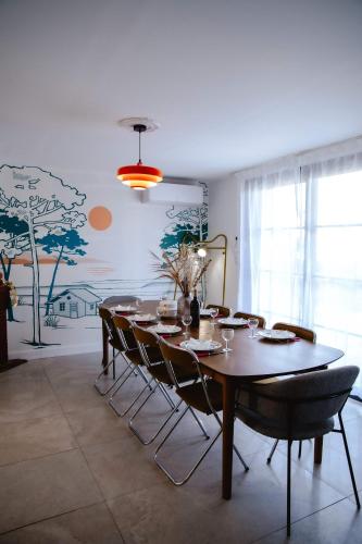 a dining room with a table and chairs in a room at Maison Castor, balnéo et billard chez Ivona Vacances in Mimizan