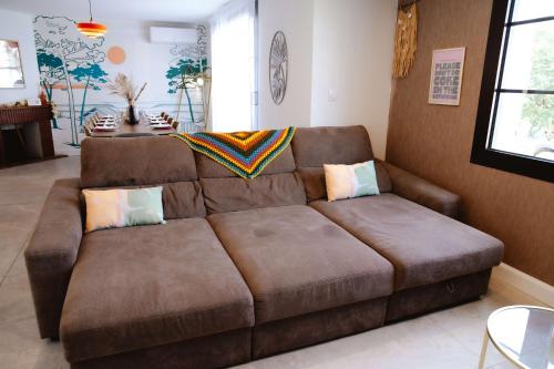 a brown leather couch in a living room at Maison Castor, balnéo et billard chez Ivona Vacances in Mimizan