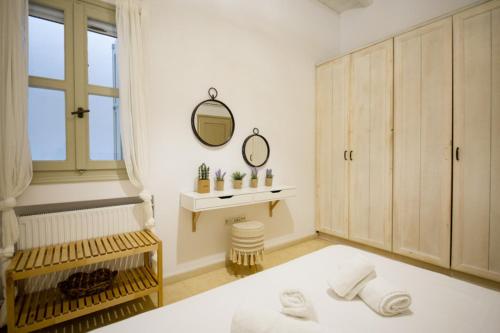 a white bathroom with a tub and a mirror at Marvi House Mykonos Holiday Home in Ornos