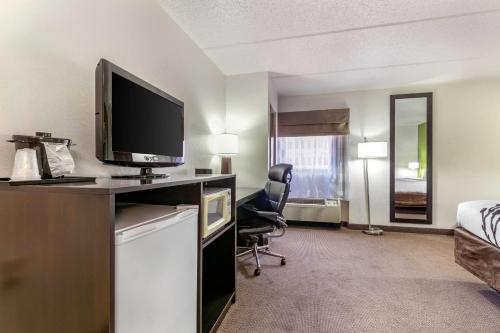 a hotel room with a desk with a tv and a chair at Sleep Inn & Suites near Sports World Blvd in Gatlinburg