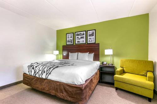 a hotel room with a bed and a yellow chair at Sleep Inn & Suites near Sports World Blvd in Gatlinburg