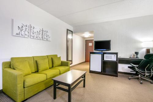 a living room with a yellow couch and a tv at Sleep Inn & Suites near Sports World Blvd in Gatlinburg