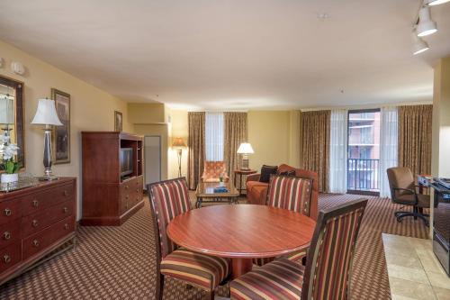 a hotel room with a table and chairs and a living room at Clarion Collection Hotel Arlington Court Suites in Arlington
