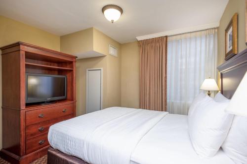 a hotel room with a bed and a television at Clarion Collection Hotel Arlington Court Suites in Arlington
