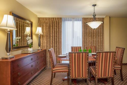 a dining room with a table and chairs and a mirror at Clarion Collection Hotel Arlington Court Suites in Arlington